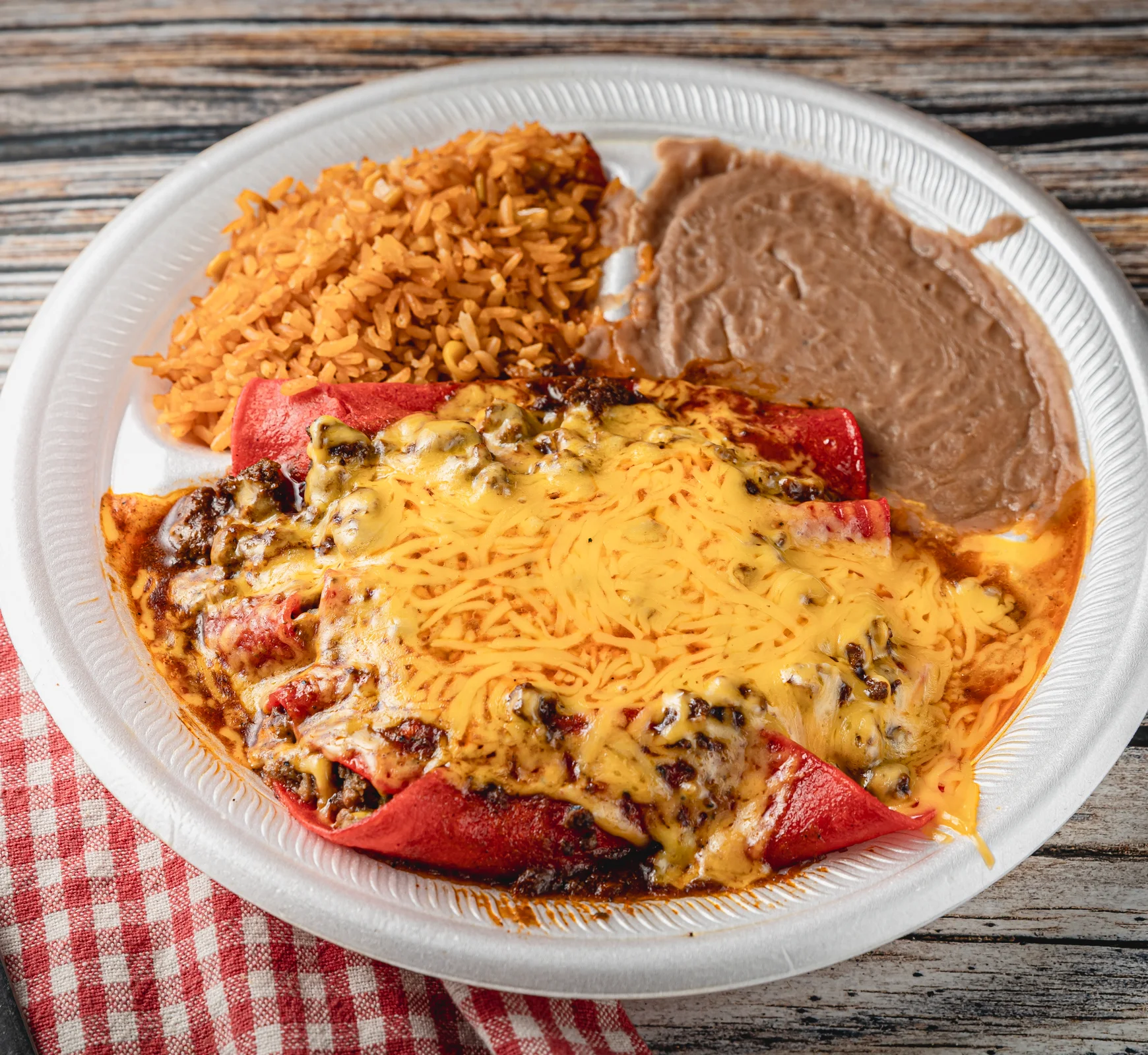 A plate of rice, beans, and cheesy enchiladas