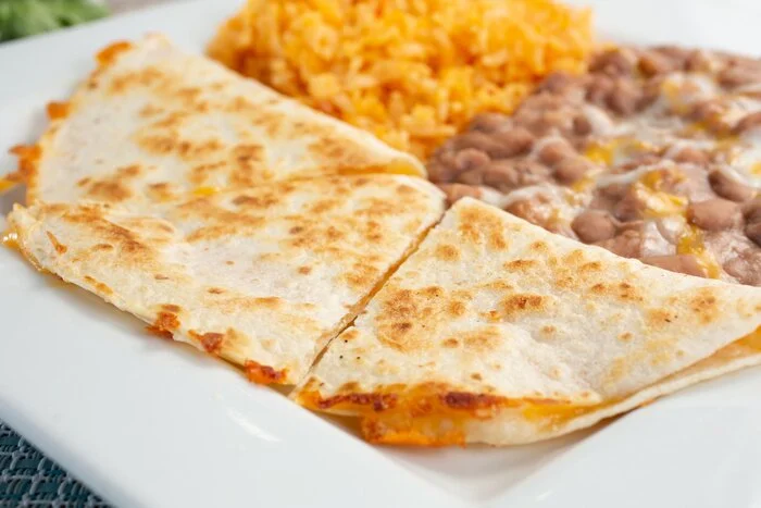 Delicious Mexican quesadillas served with rice and refried beans