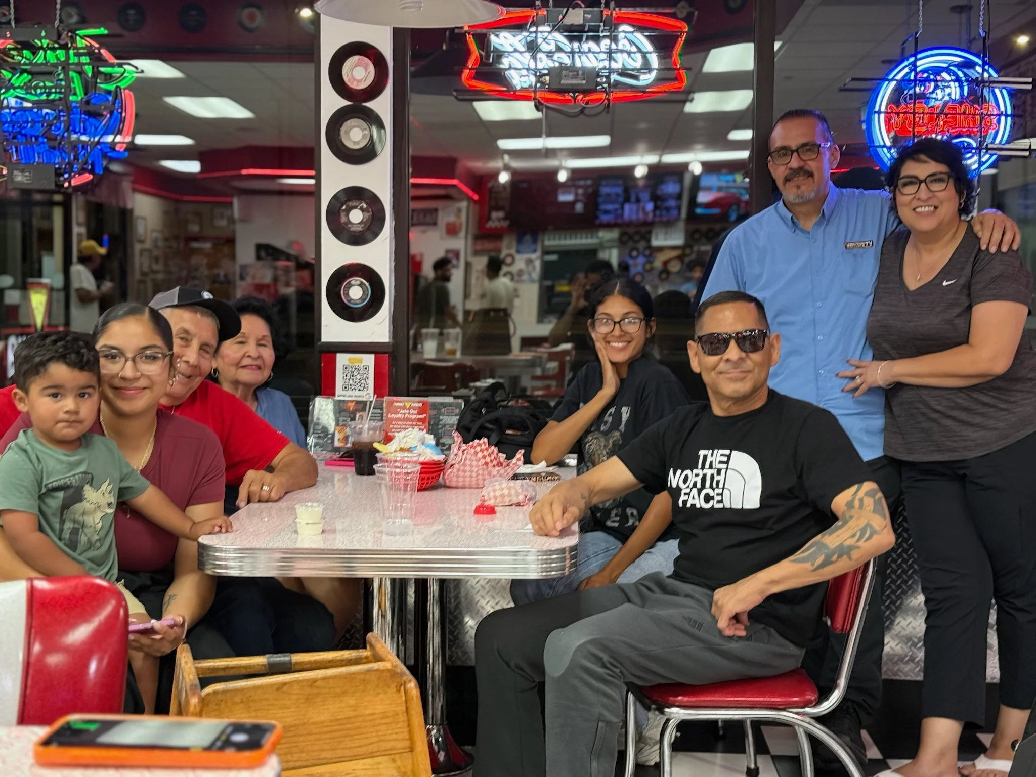 Family gathering in a retro diner with neon lights