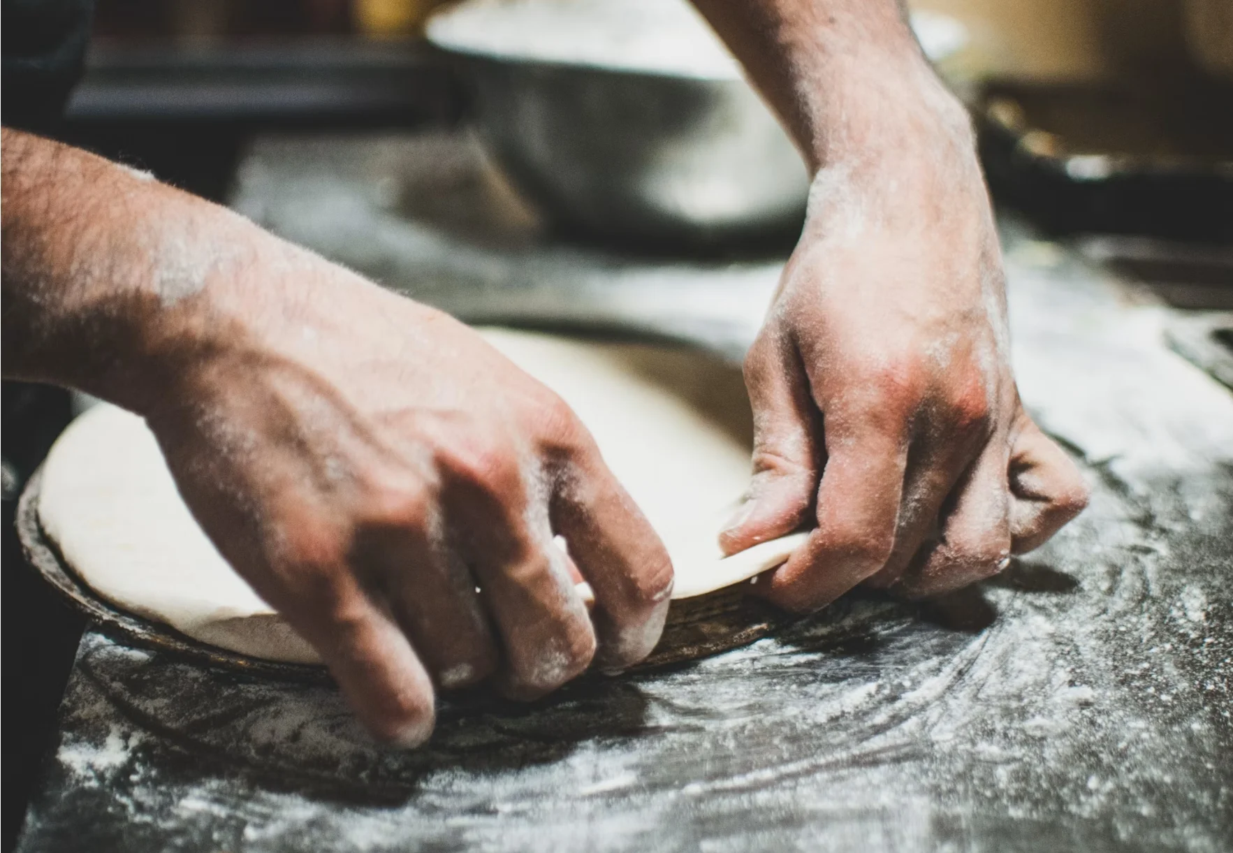 Chef preparing pizza dough on a floured surface