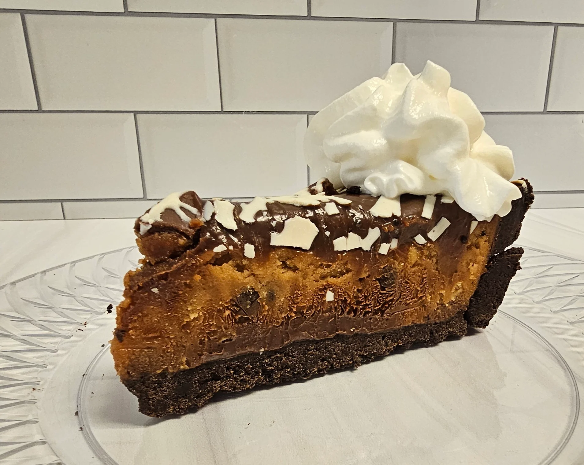 Decadent chocolate chip cheesecake slice with whipped cream