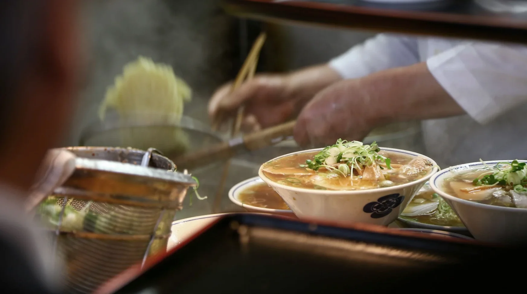Japanese ramen being prepared with steaming broth