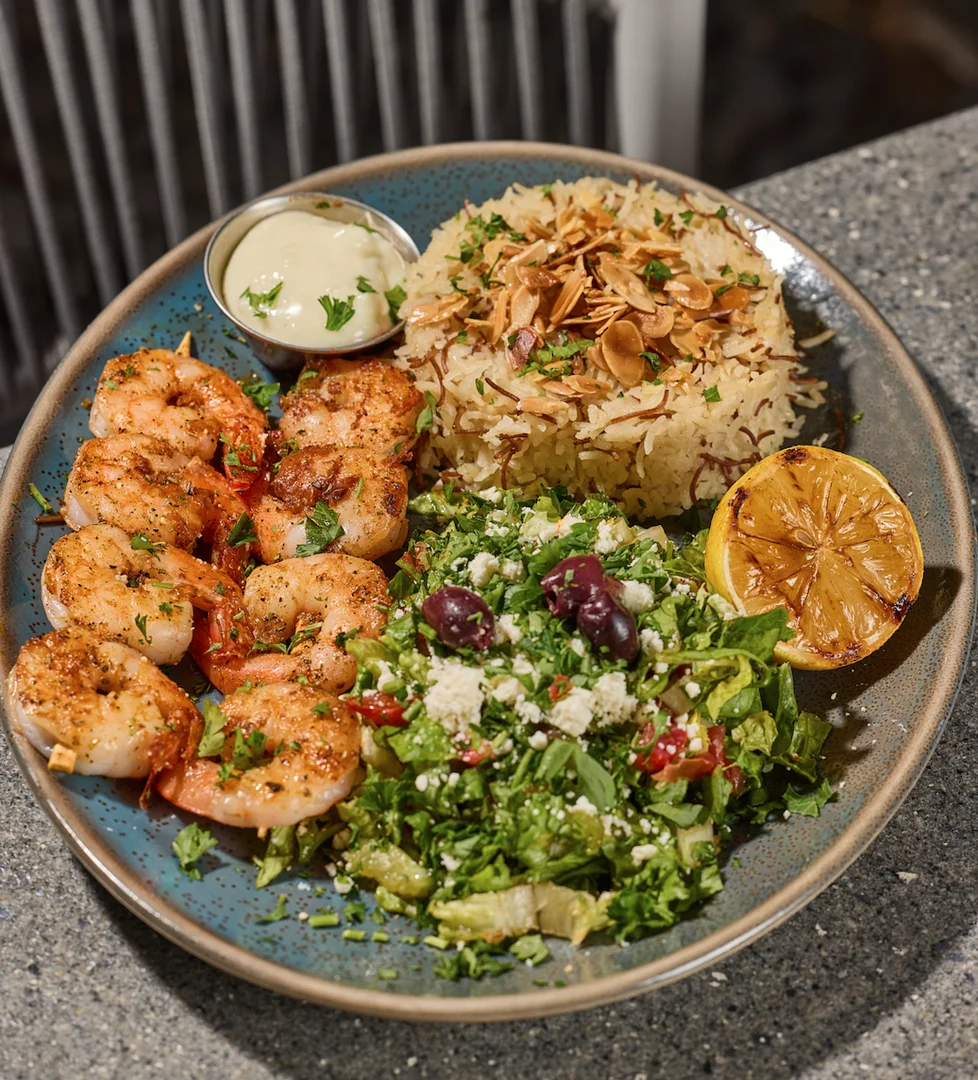 Two skewers of shrimp marinated in garlic, lemon juice and olive oil grilled to perfection at Sufrat Grill.