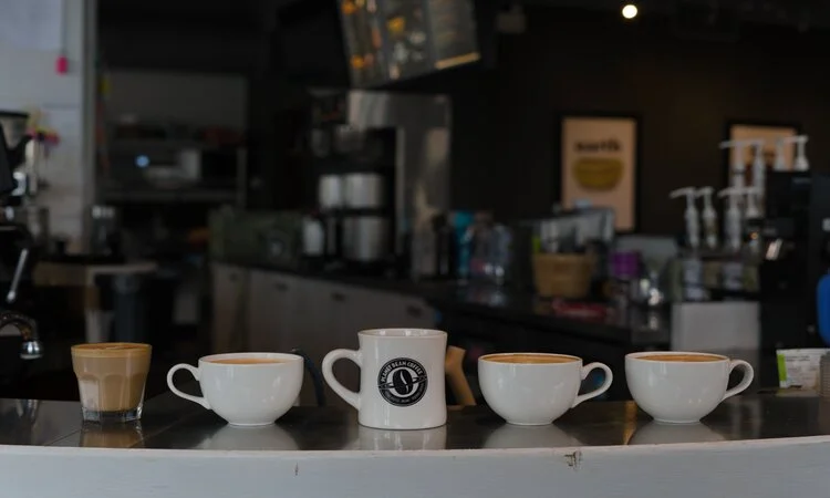 Variety of coffee cups displayed at a modern café counter