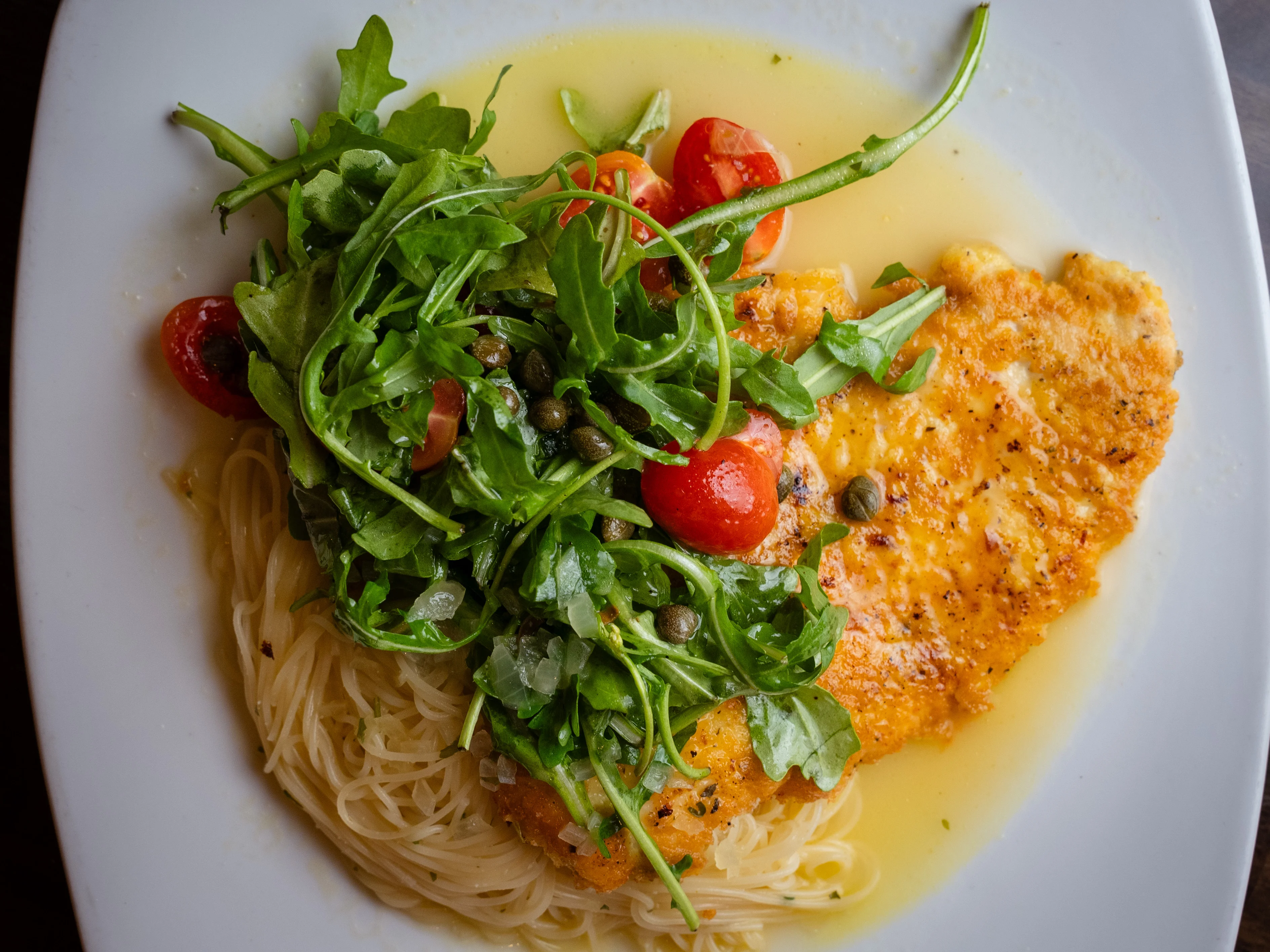 Italian piccata with arugula and cherry tomatoes