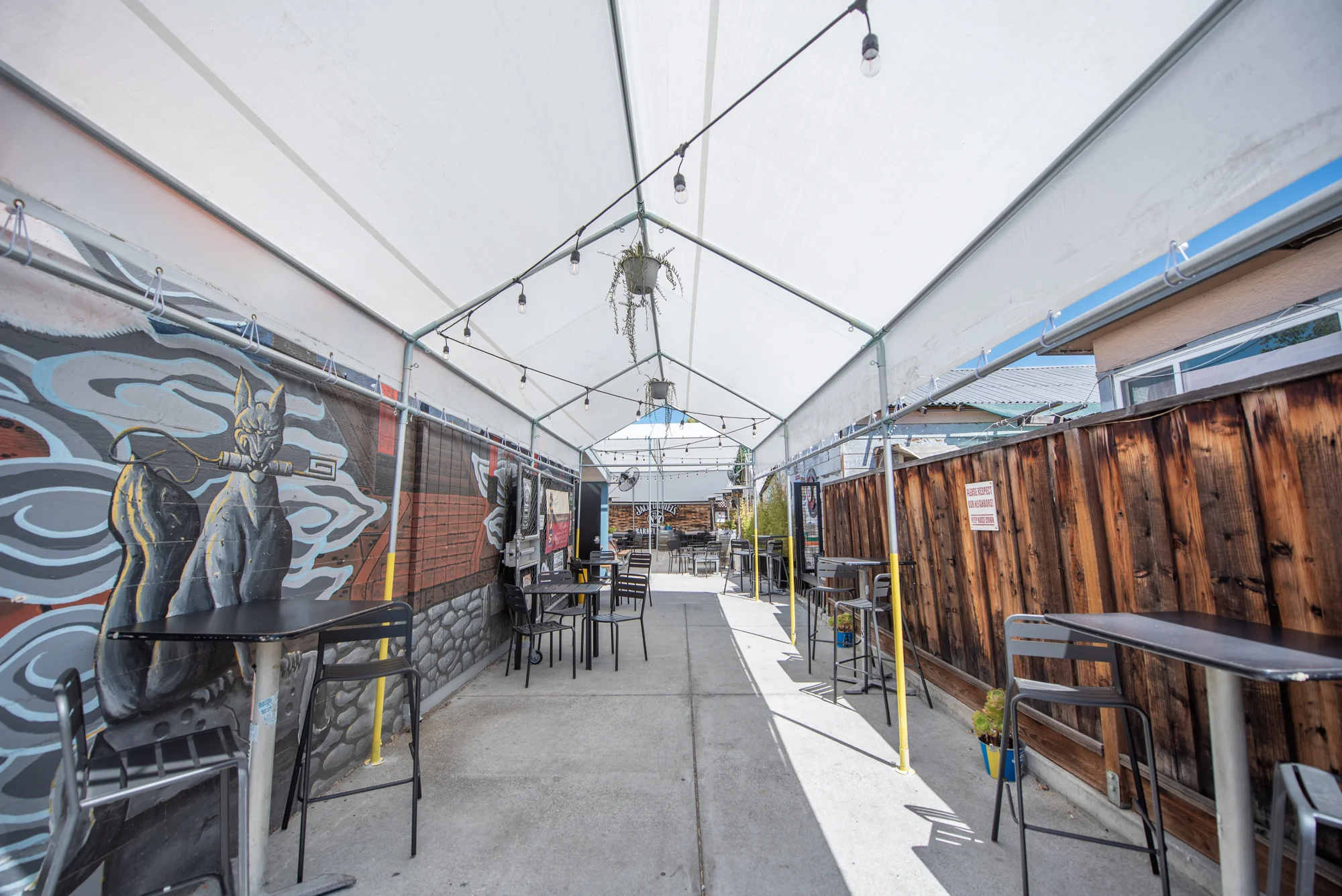 Outdoor dining area with vibrant mural and string lights