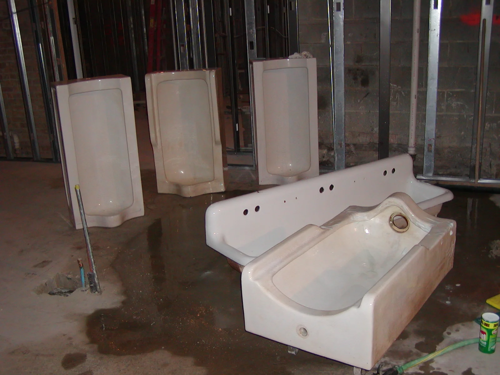 Restroom fixtures including urinals and a sink in a construction site