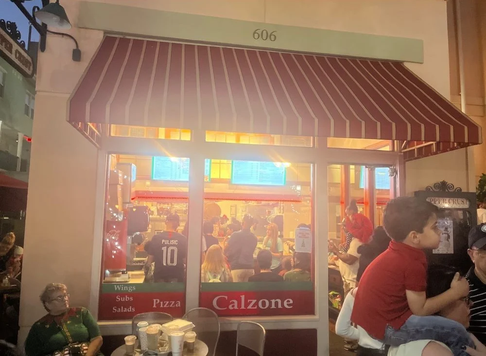 Cozy restaurant exterior with striped awning and warm lighting