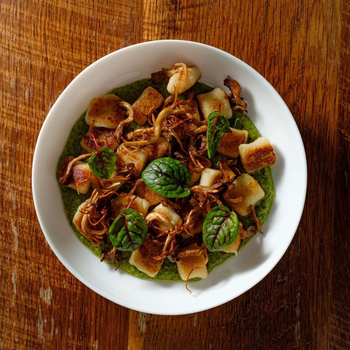 Delicious gnocchi served on vibrant green sauce