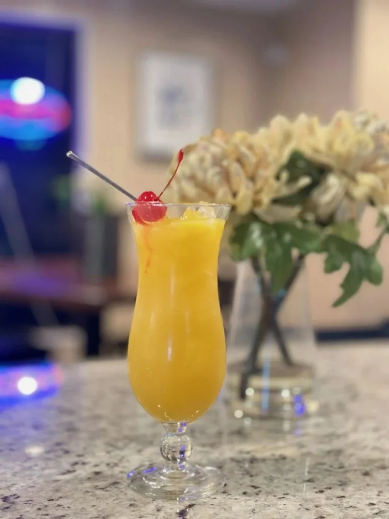 Tropical cocktail with orange juice and cherry garnish