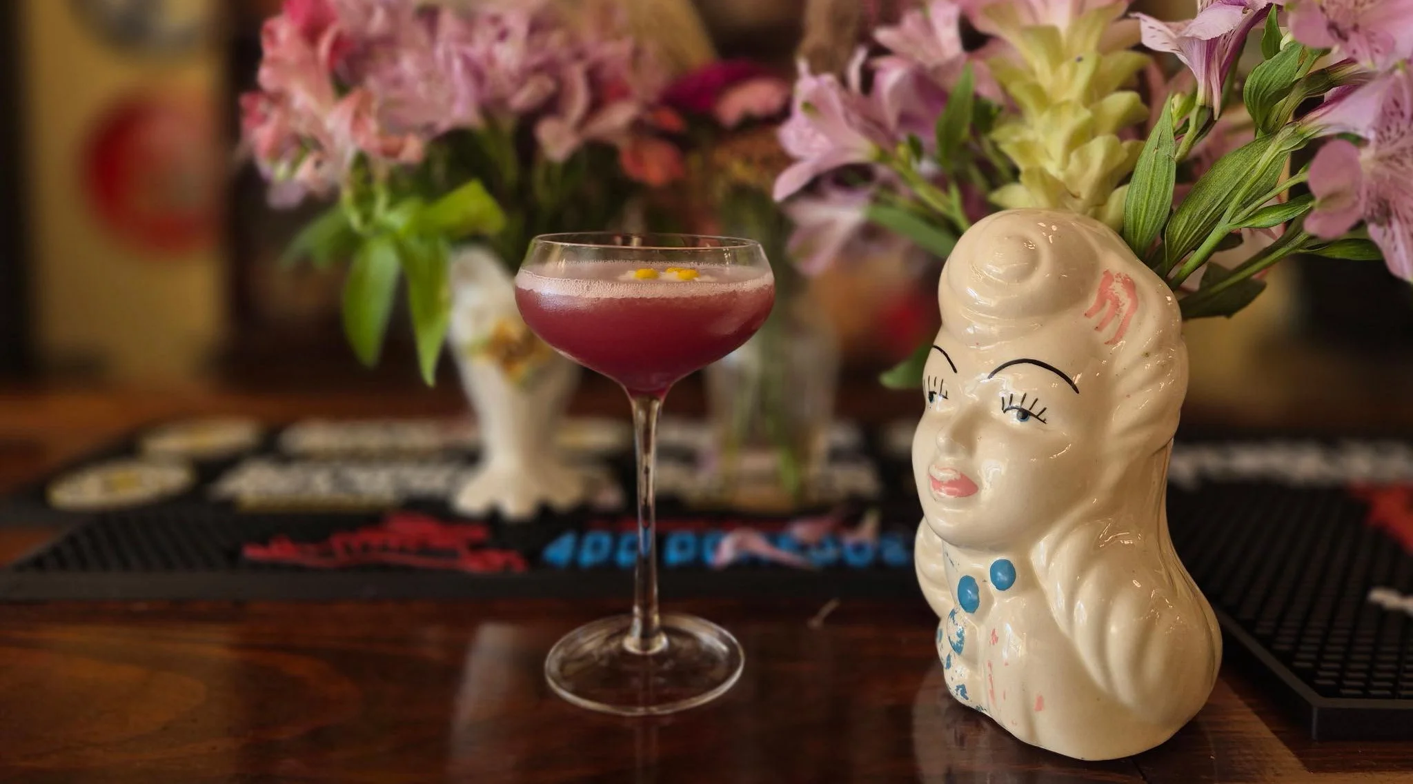 Colorful cocktail served in a vintage glass with floral decor