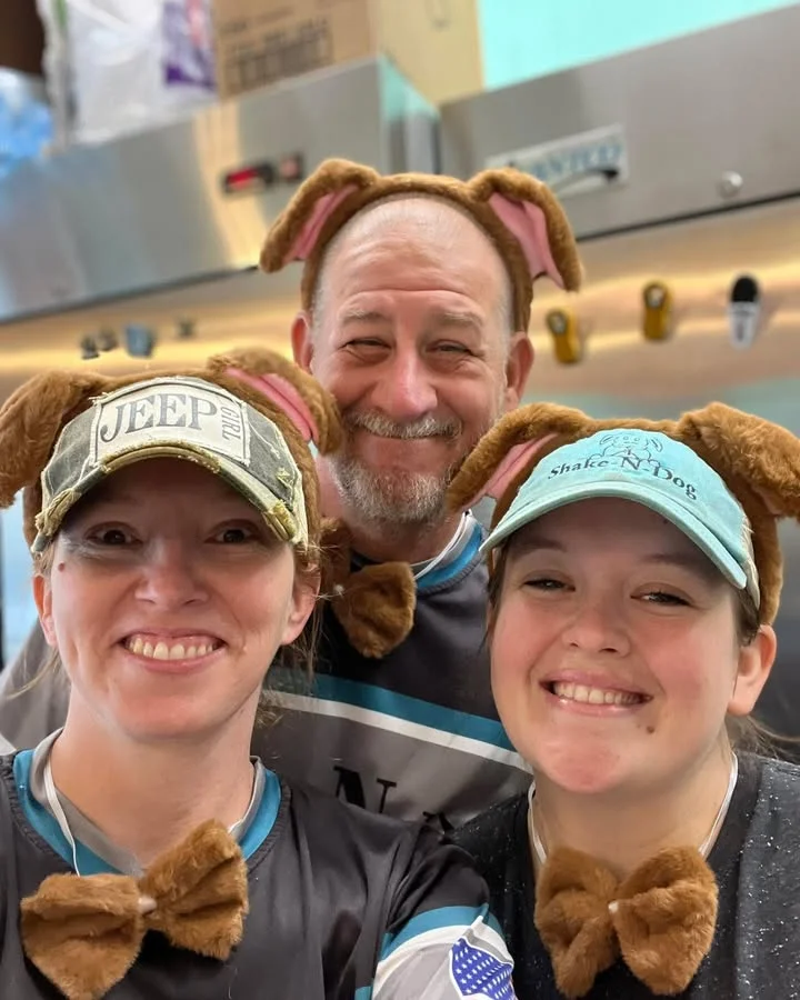Staff wearing dog-themed hats and bowties at a fun restaurant
