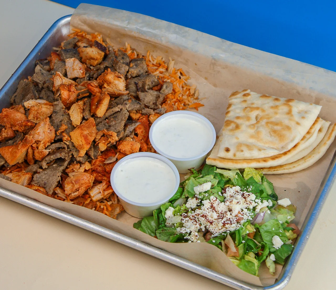 A falaffel platter with a salad and tortillas 