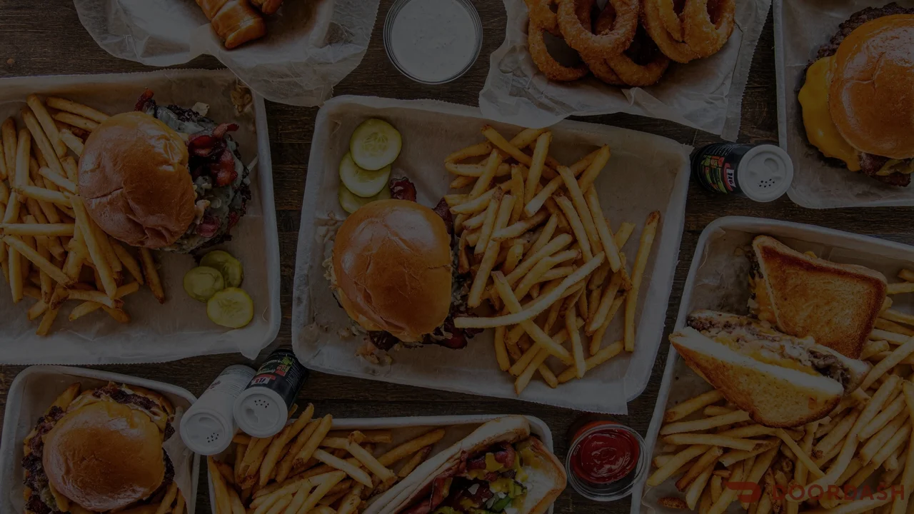 Delicious American burgers with fries and onion rings on a wooden table