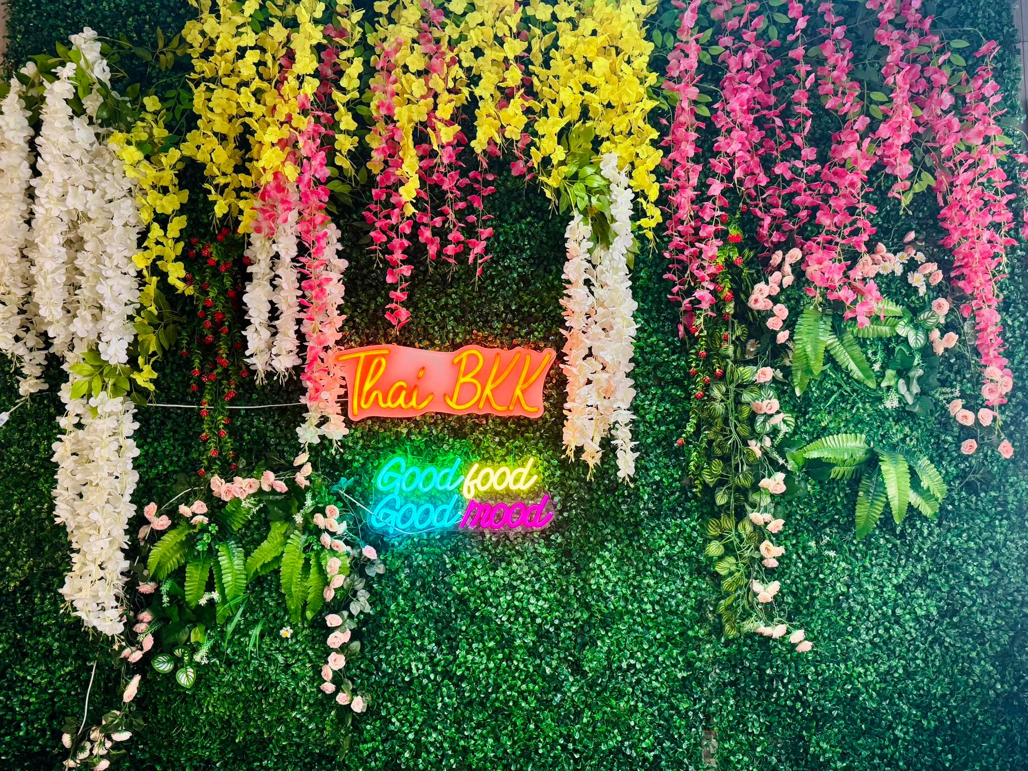 Vibrant Thai restaurant decor with neon signs and floral arrangements
