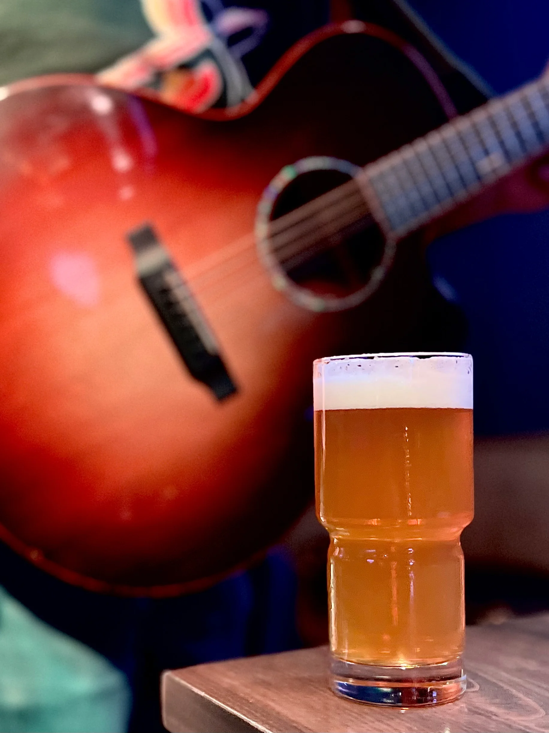 Craft beer served with an acoustic guitar in a cozy bar setting
