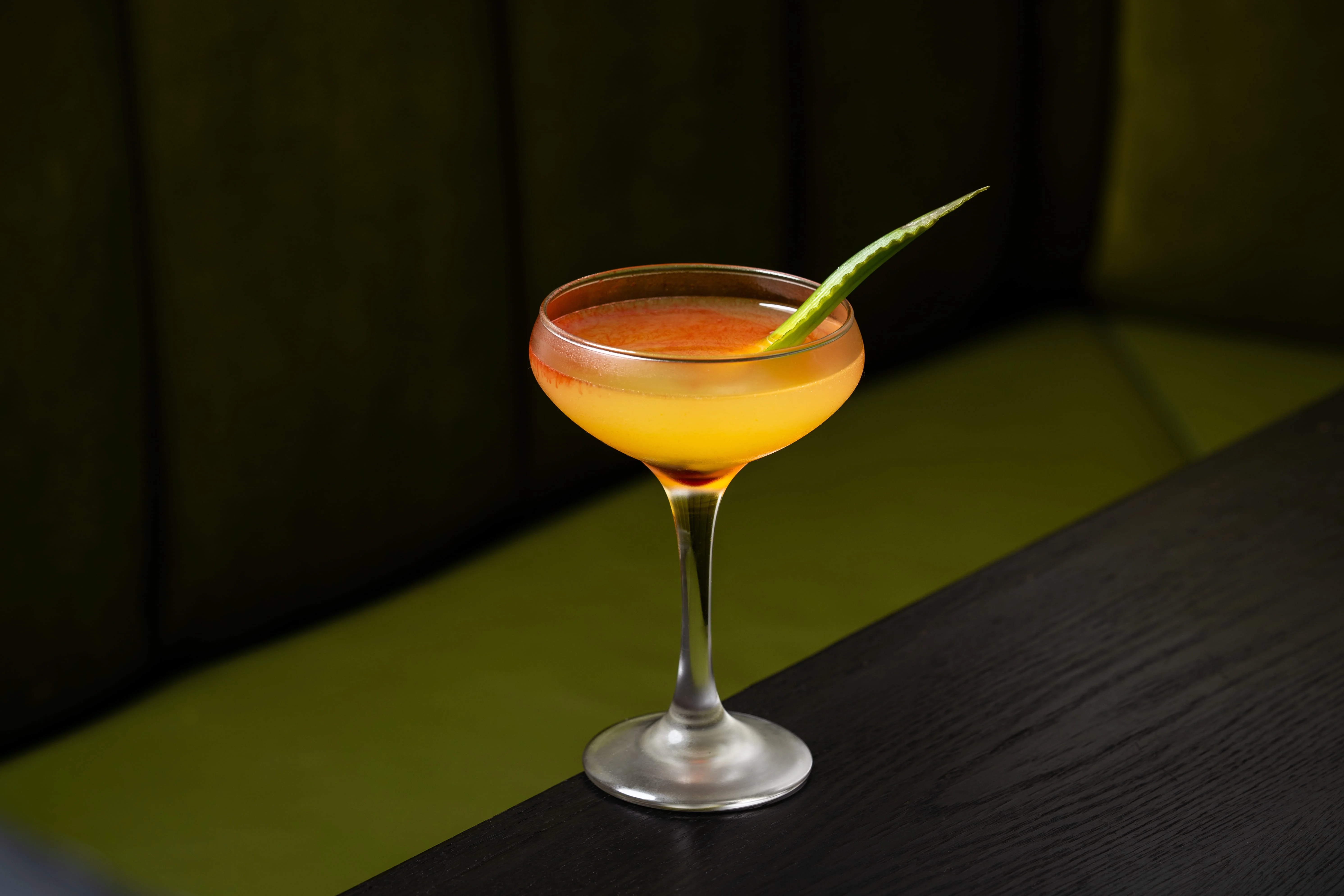 Vibrant cocktail served in a coupe glass with a garnish