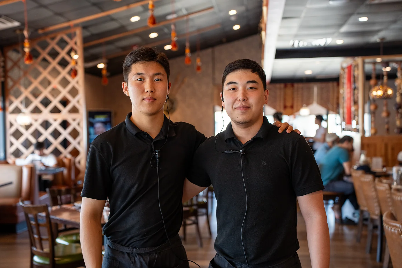 Two restaurant staff members posing in a cozy dining area