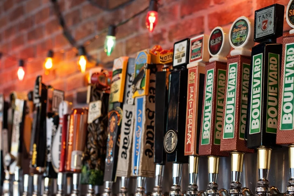 Craft beer taps lined up in a cozy bar with warm lighting