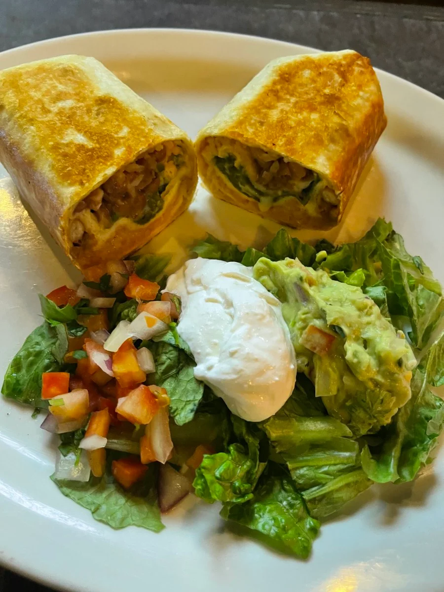 Crispy chicken burrito with fresh salad and guacamole
