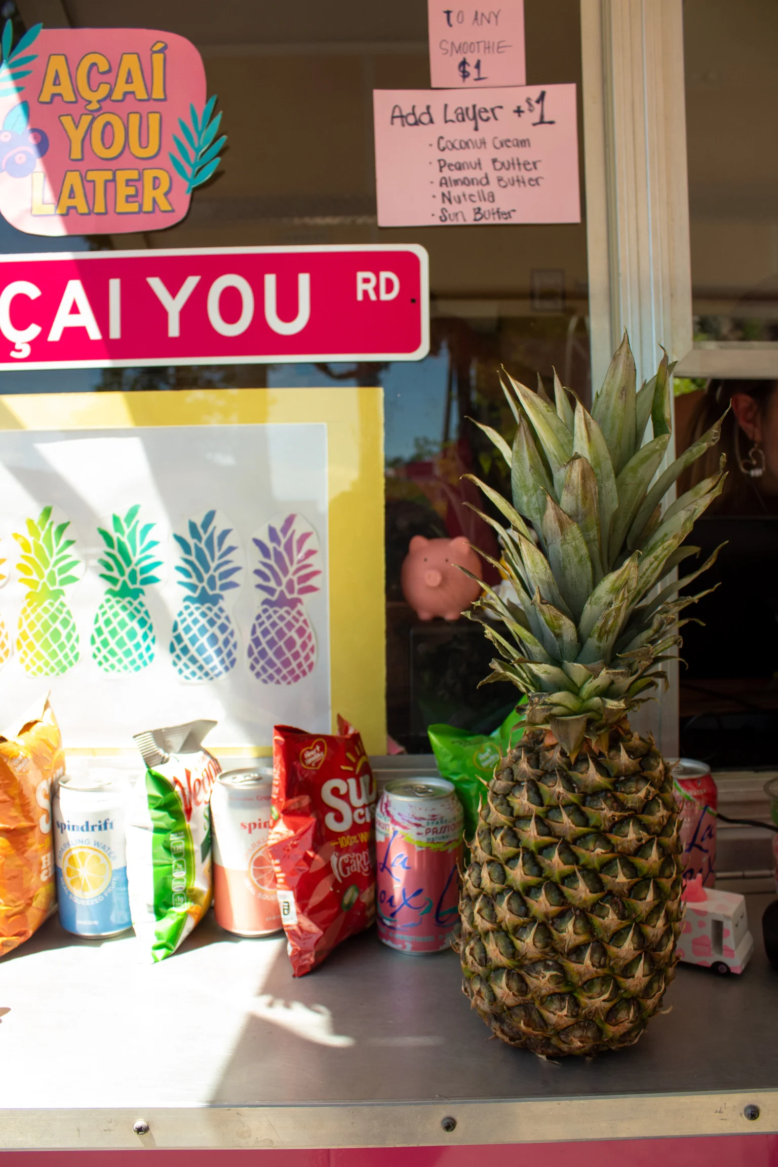 Colorful smoothie shop display with fresh pineapple and snacks