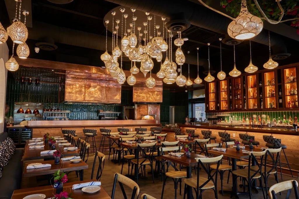 Warmly lit dining room and bar at Sufrat Mediterranean Grill in Doral.