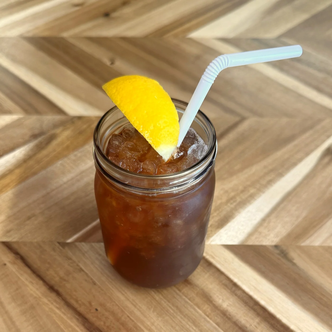 Iced tea with lemon wedge in a glass jar