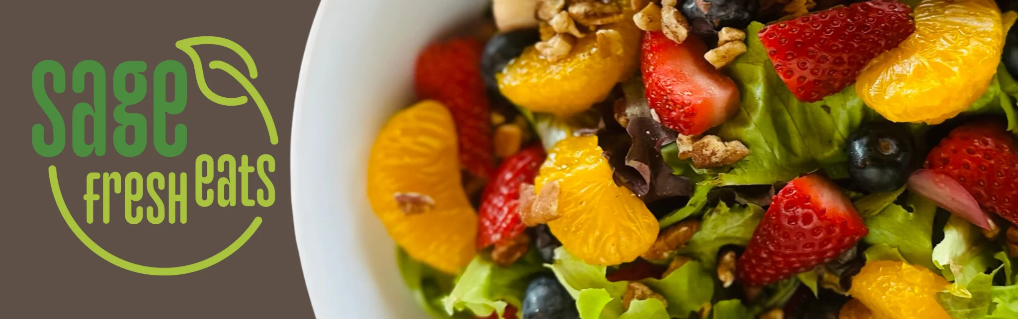 Colorful fruit salad in a fresh greens bowl