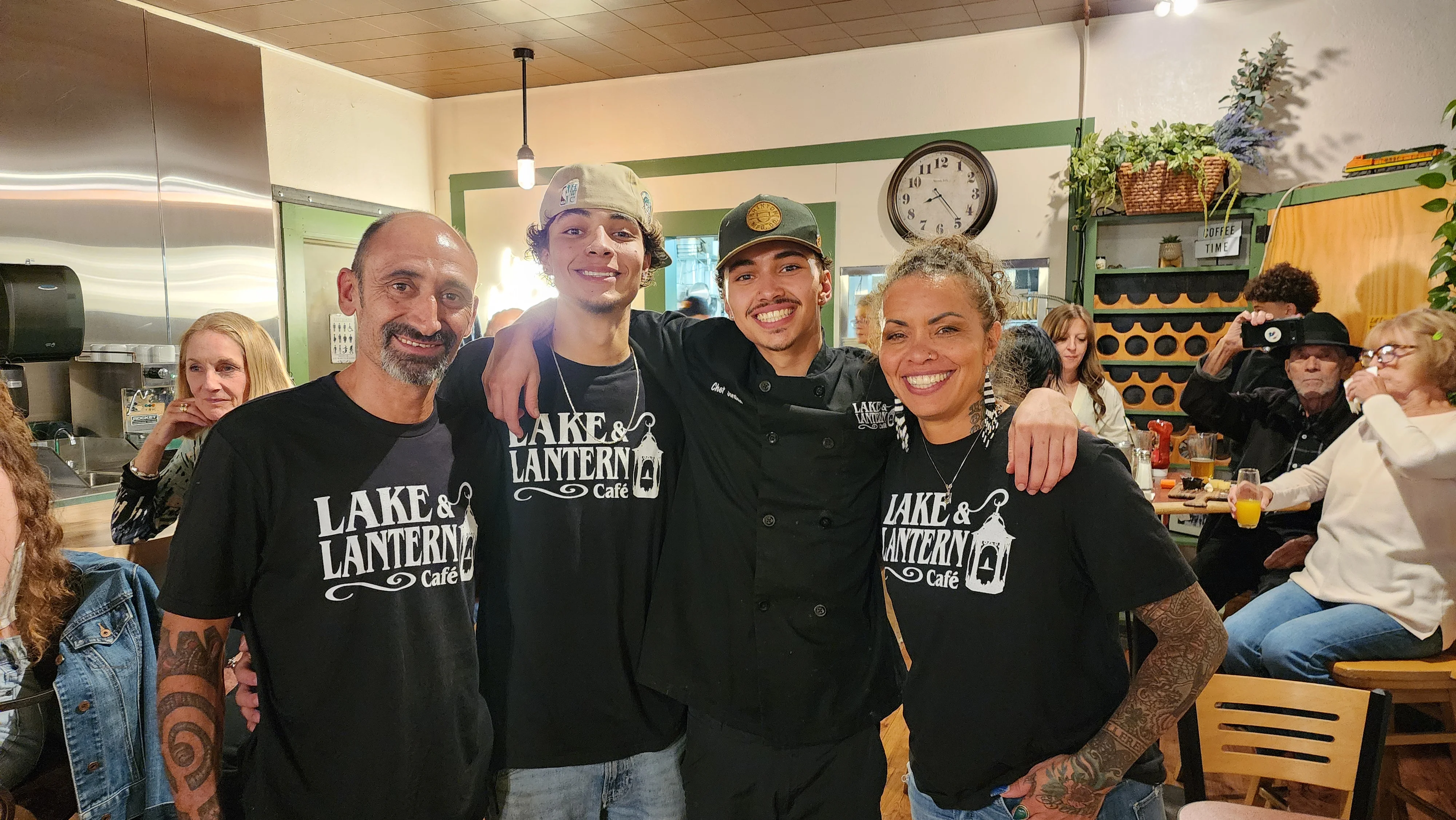 Friendly staff at Lake & Lantern Café posing together in a cozy restaurant setting