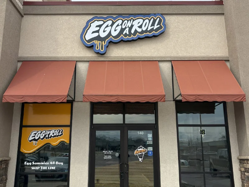 Exterior of Egg on a Roll restaurant with signage and awnings