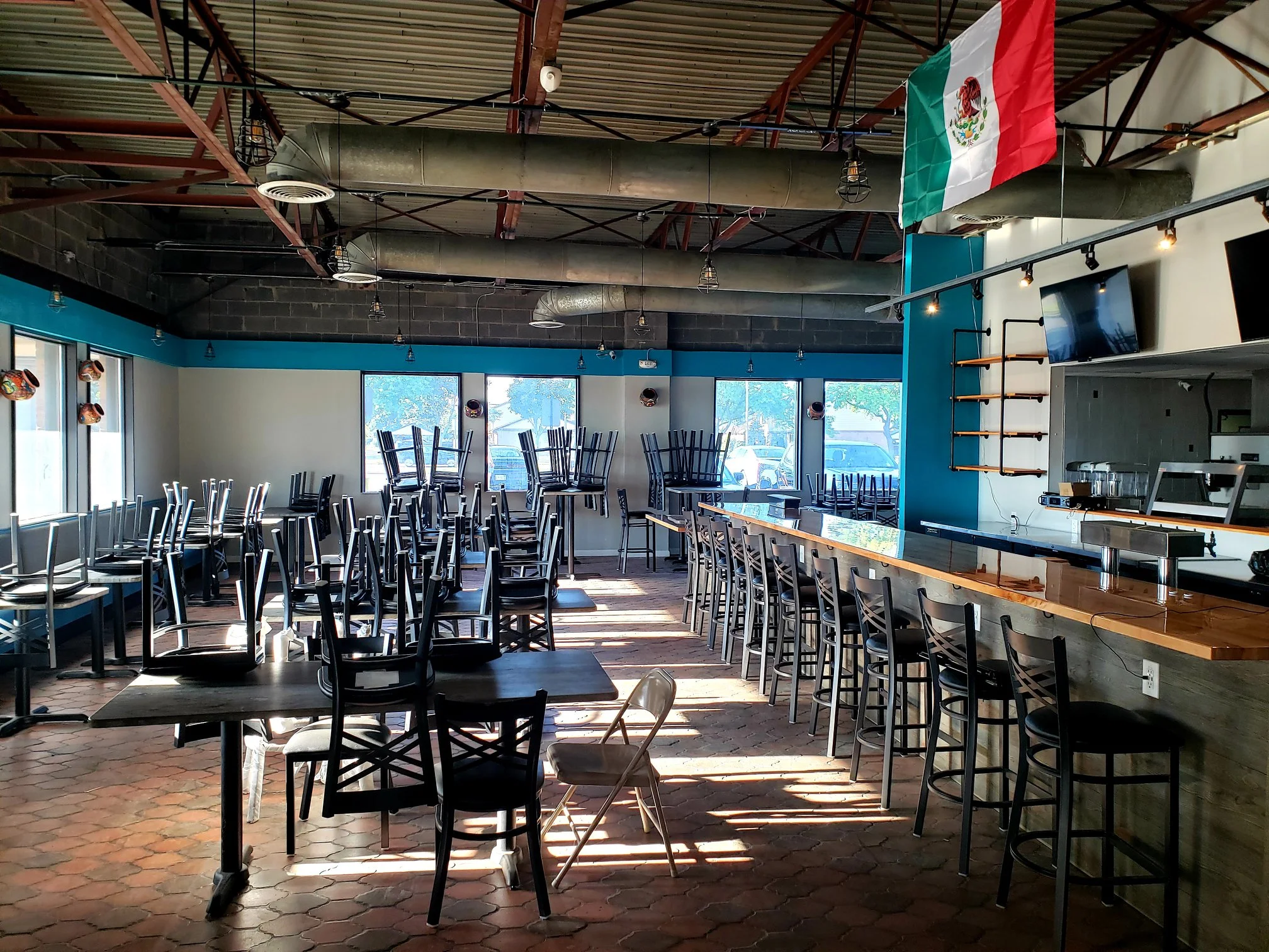 Modern restaurant interior with Mexican flag and empty chairs