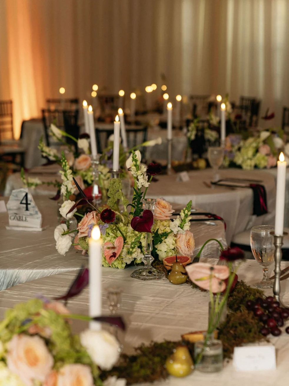 Elegant dining setup with floral centerpieces and candlelight