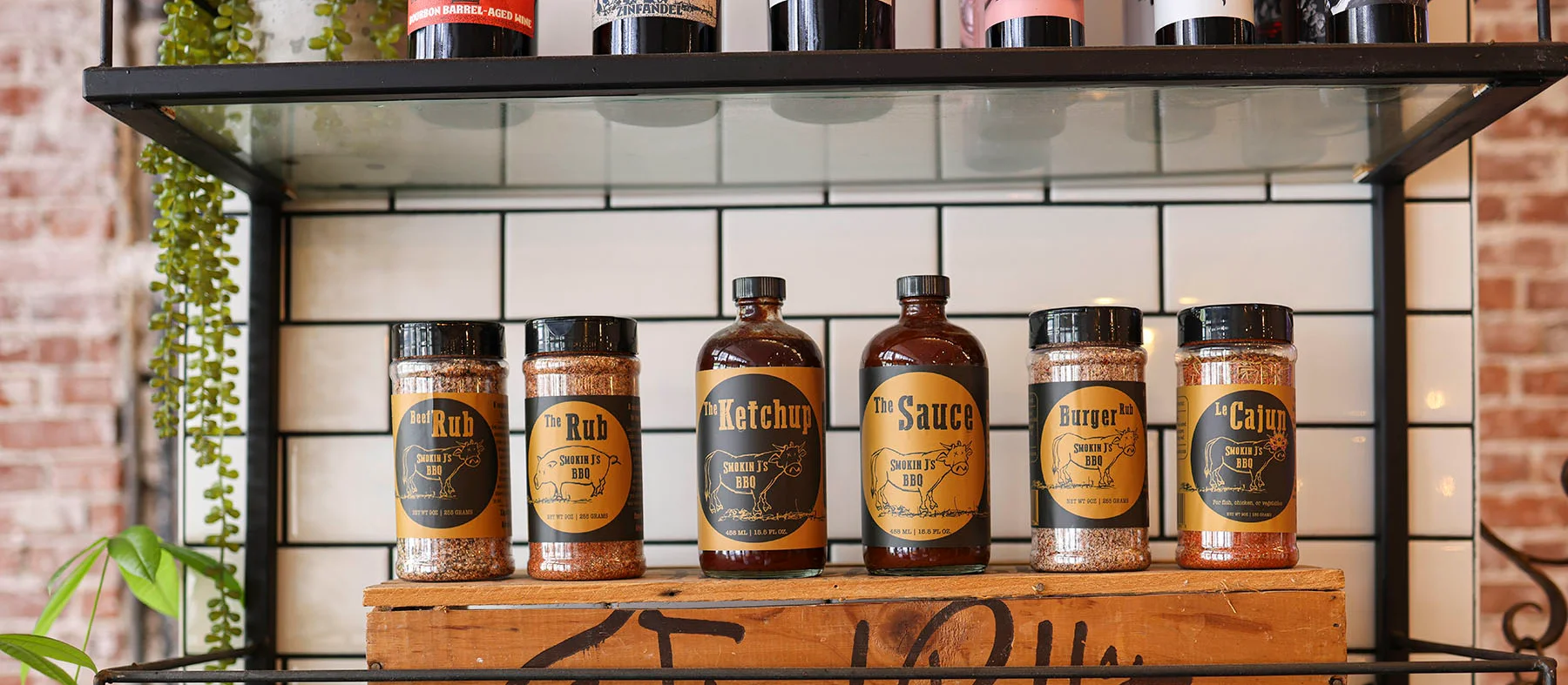 Variety of BBQ sauces and rubs on display in a rustic setting