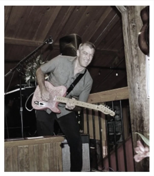 Musician performing live with electric guitar on stage