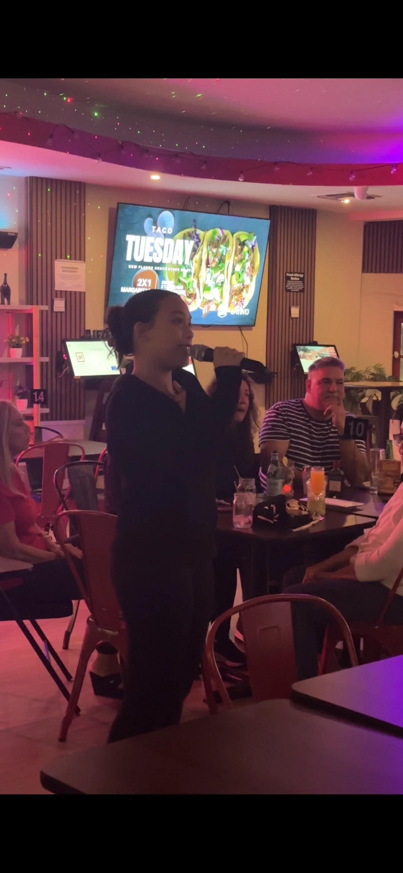 Lively restaurant scene with a performer singing karaoke