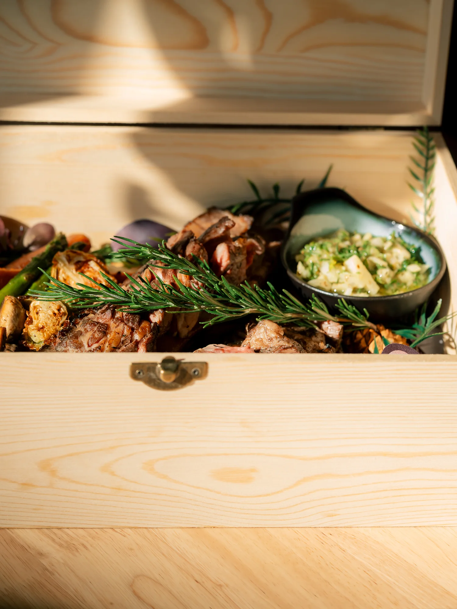 Grilled meat platter with herbs in a wooden box
