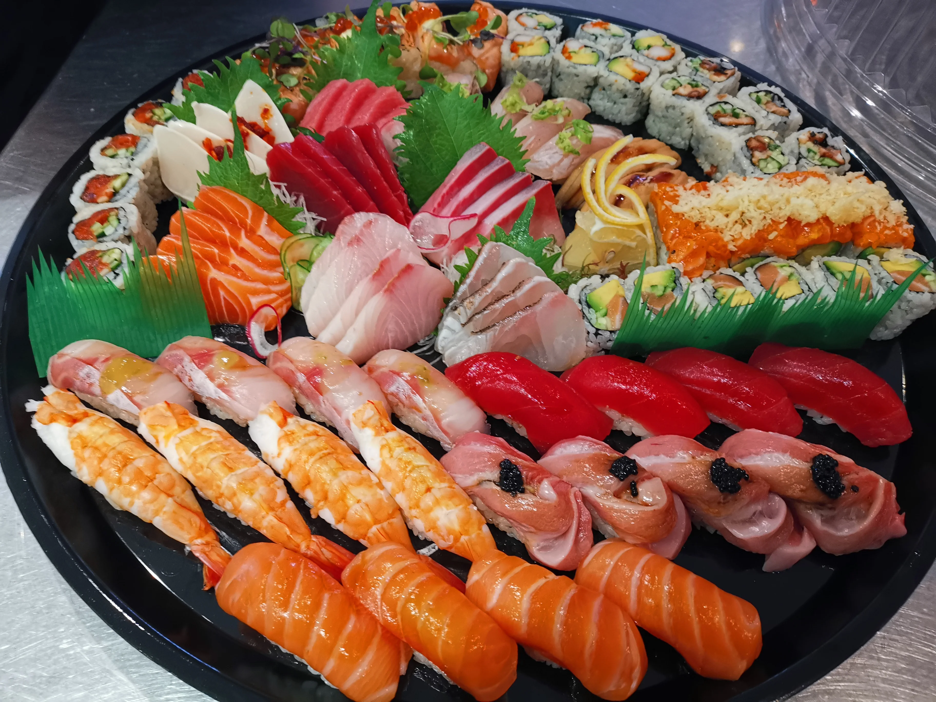 Assorted sushi rolls including tempura shrimp and avocado