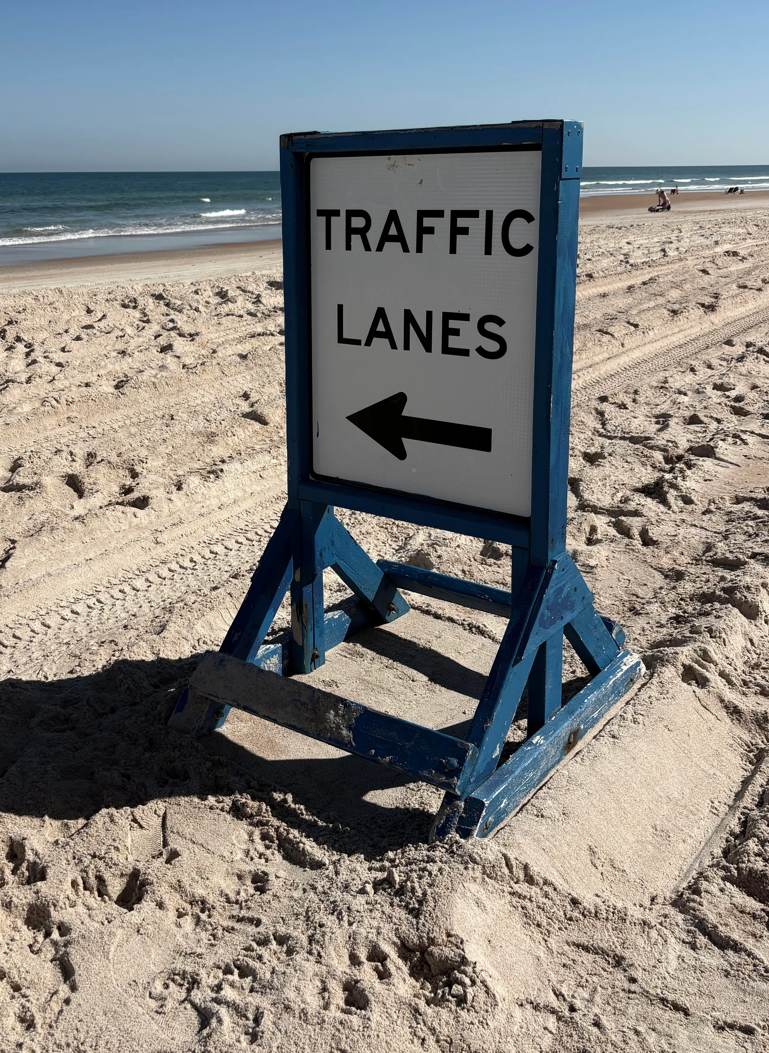 Beach sign indicating traffic lanes on sandy shore