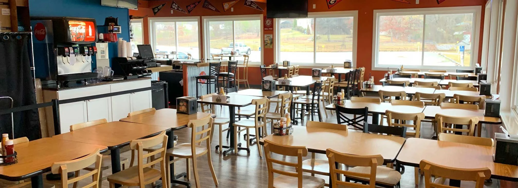Cozy restaurant interior with wooden tables and large windows