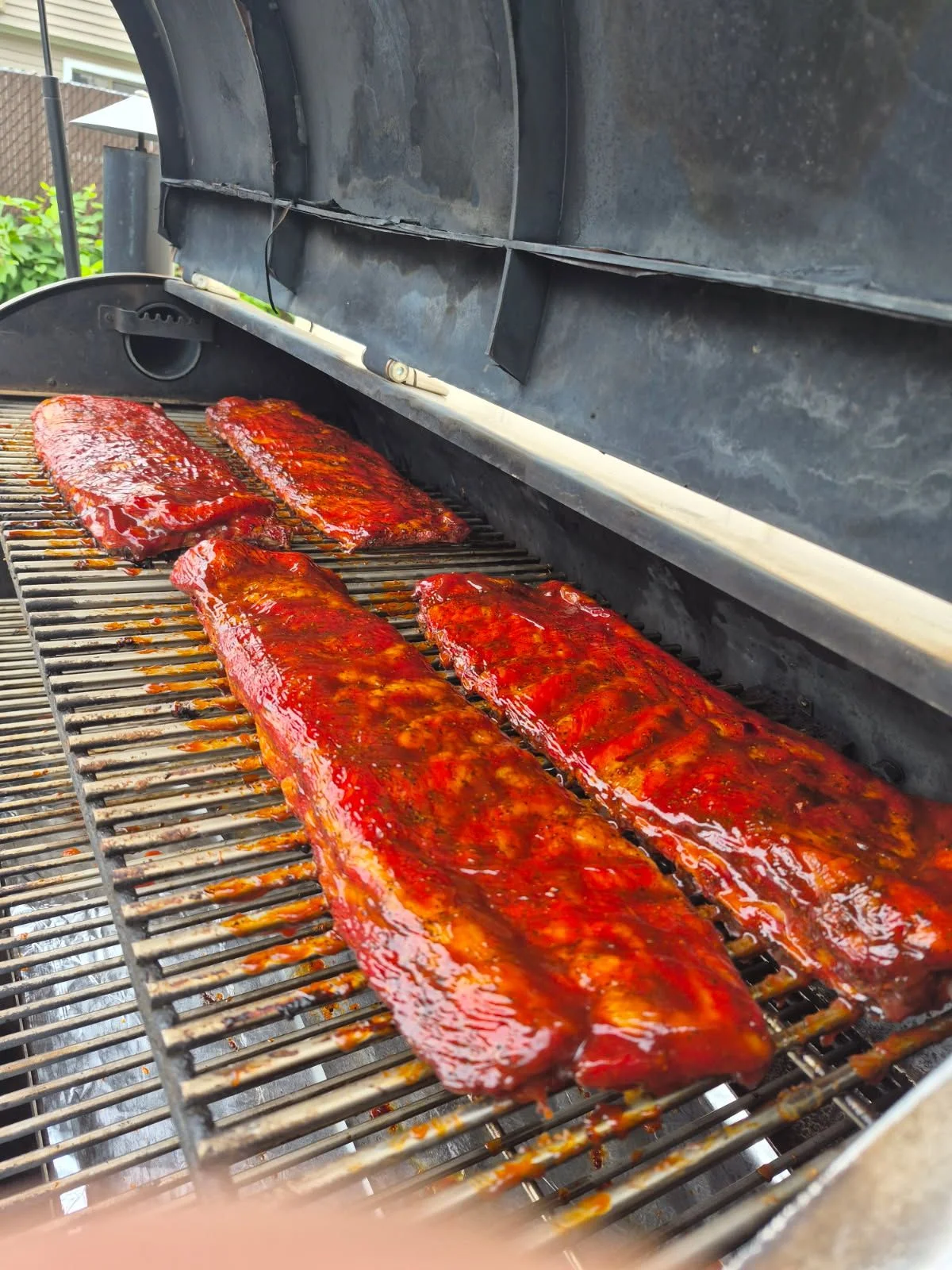 Glazed barbecue pork ribs cooking on a backyard grill