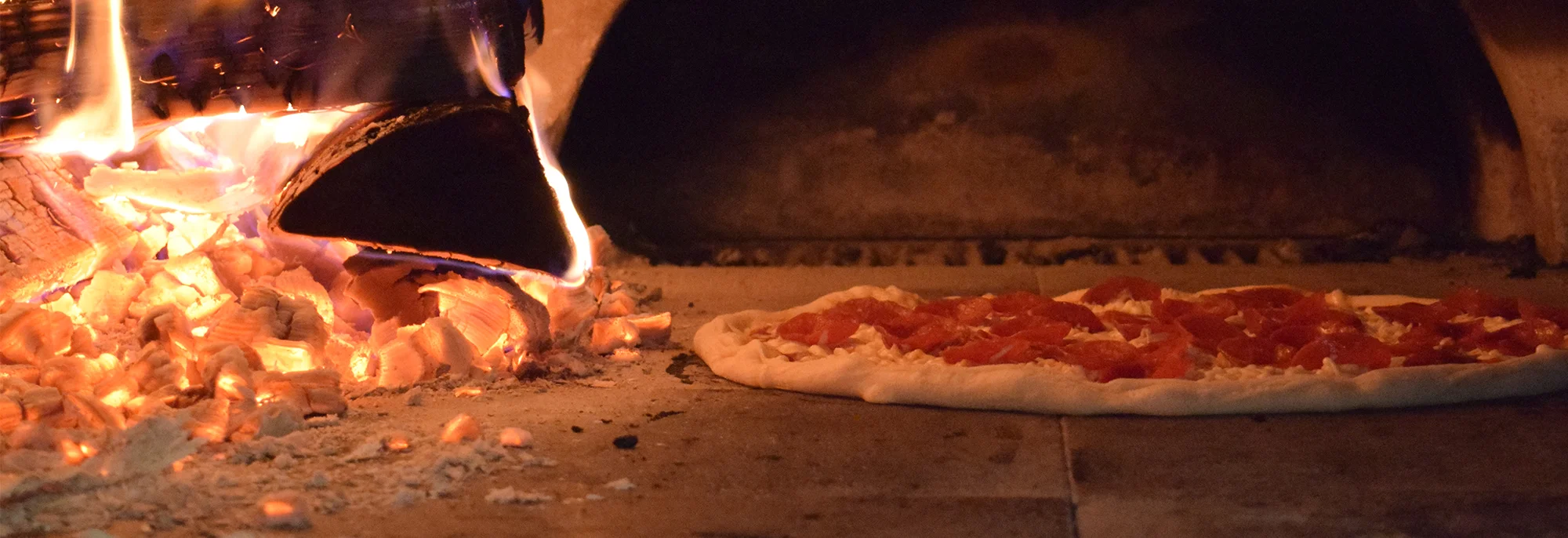 Wood-burning oven with a pepperoni pizza