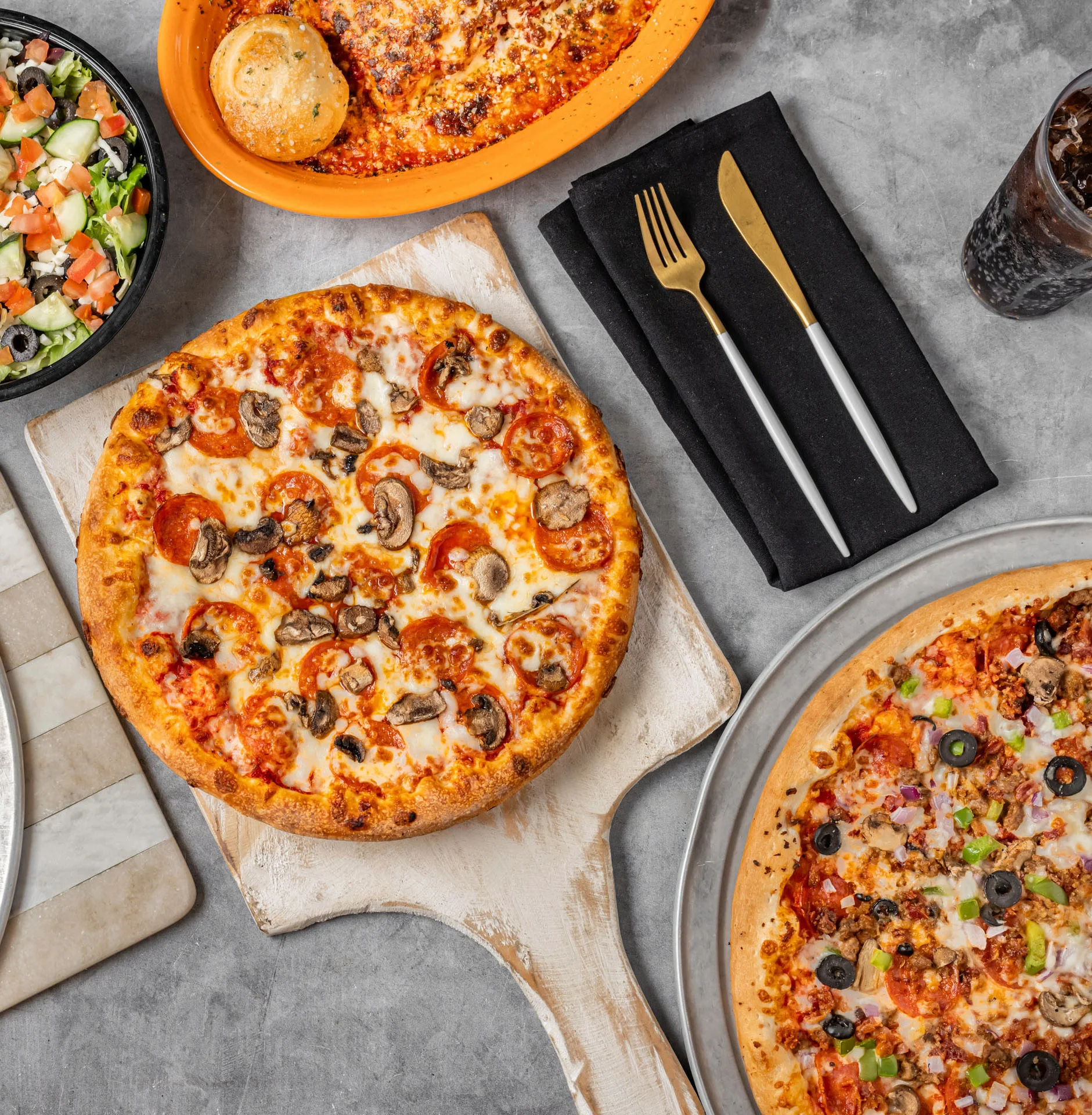 Assorted pizzas and salad in a casual dining setting