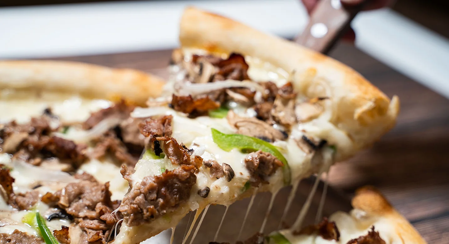 Cheesesteak pizza with melted cheese and toppings