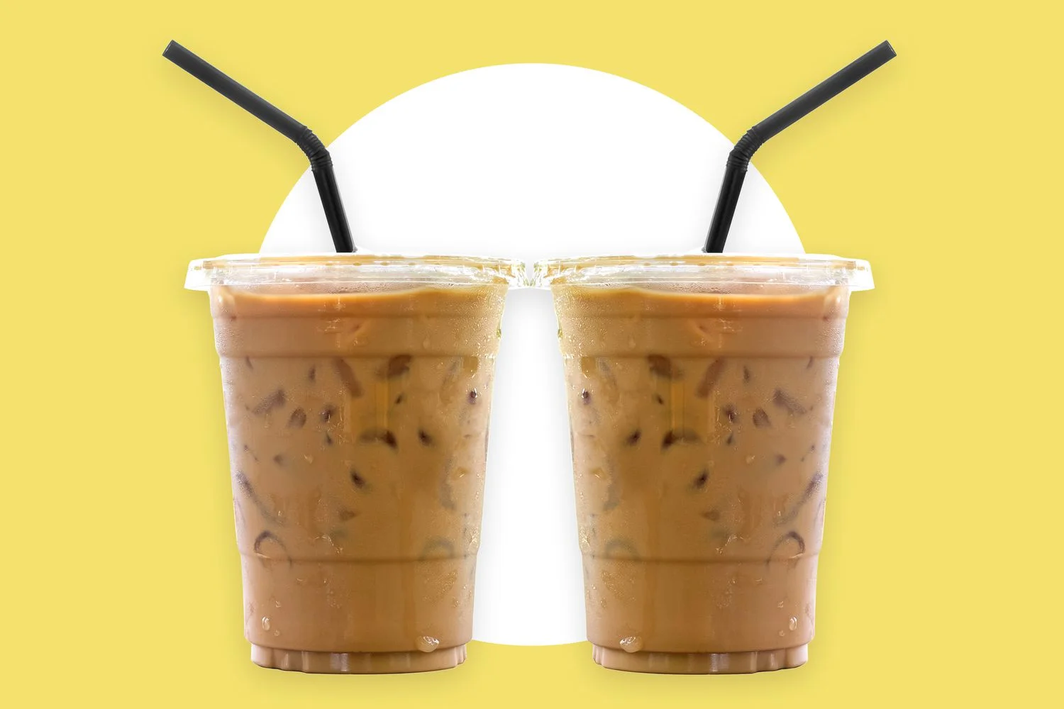 Iced coffee drinks with straws on a vibrant yellow background