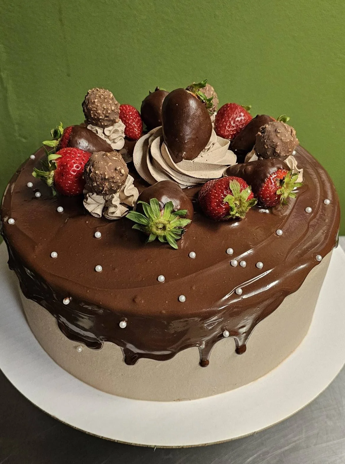 Decadent chocolate cake topped with strawberries and truffles