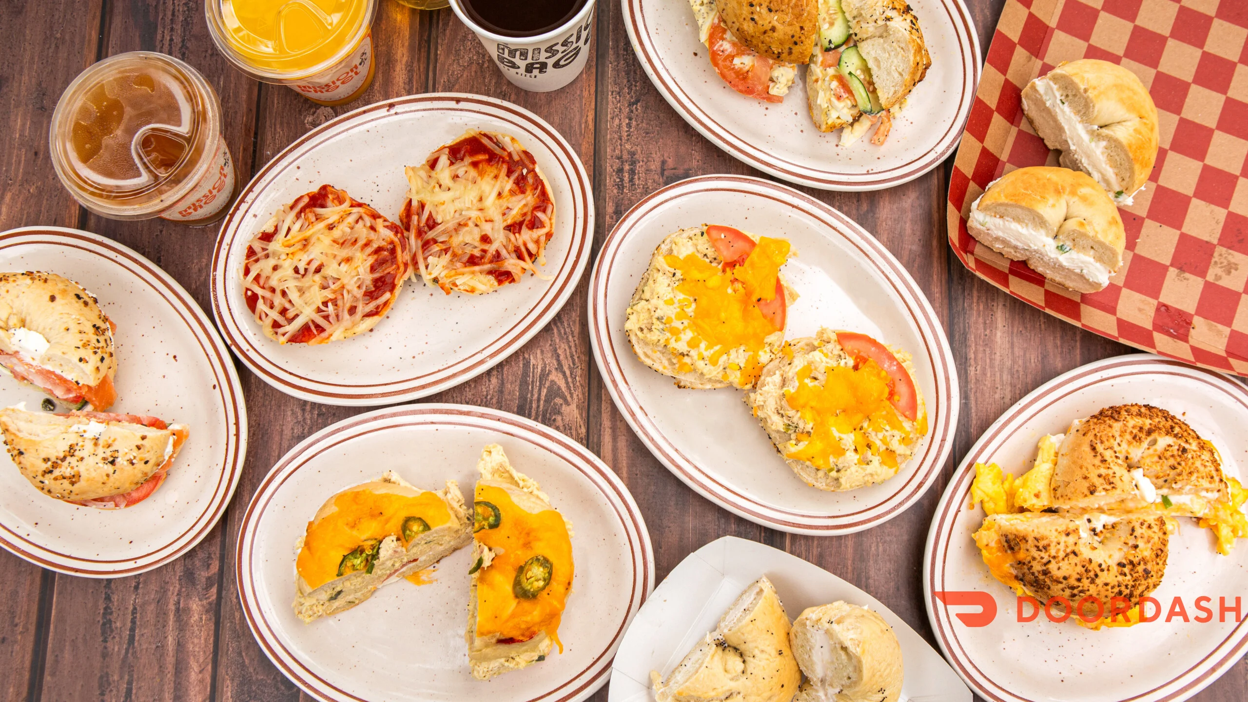 Assorted bagels and breakfast sandwiches on rustic plates