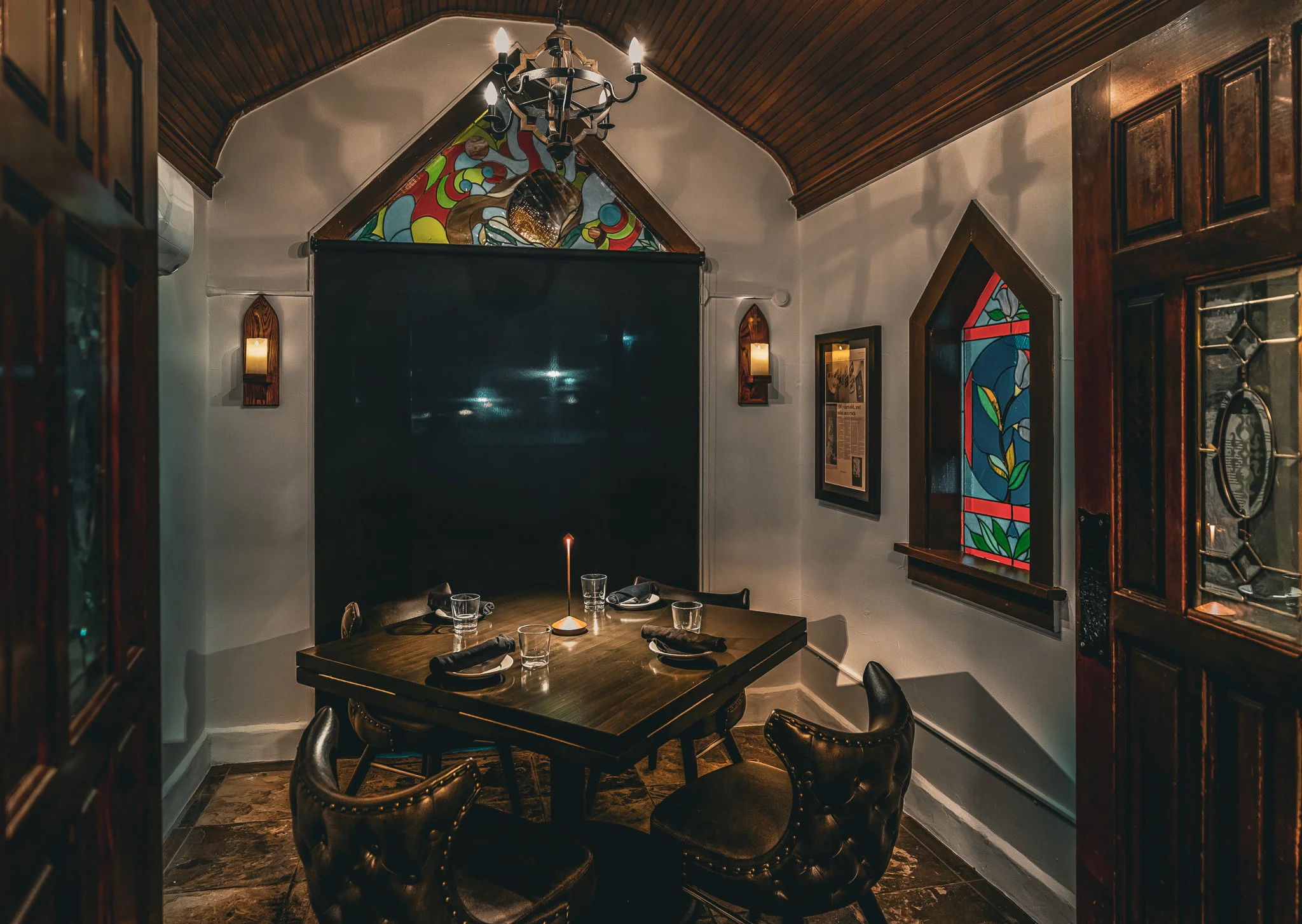 Elegant restaurant dining room with stained glass windows and candlelit table