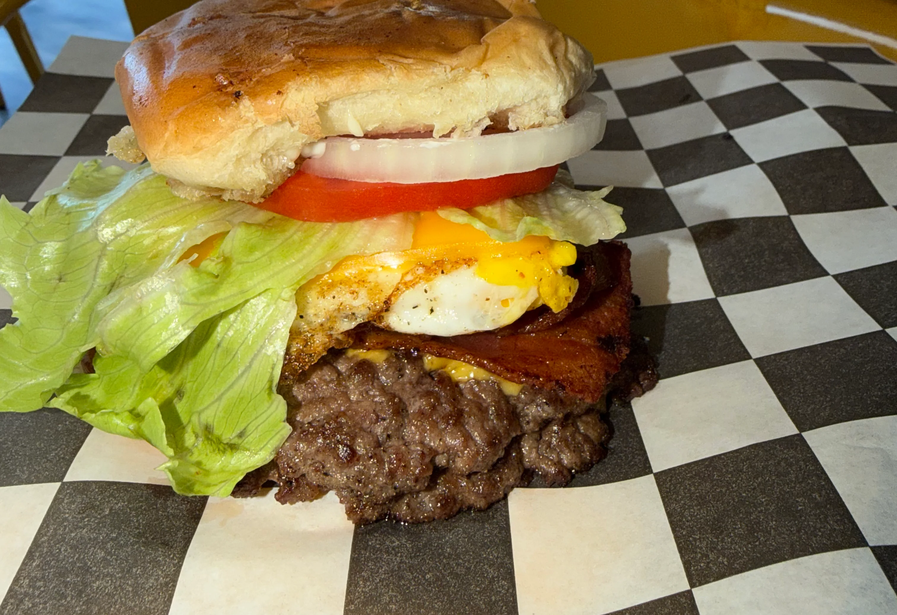 A delicious cheeseburger featuring a beef patty, cheddar cheese, and crispy bacon, all sandwiched between a toasted bun.