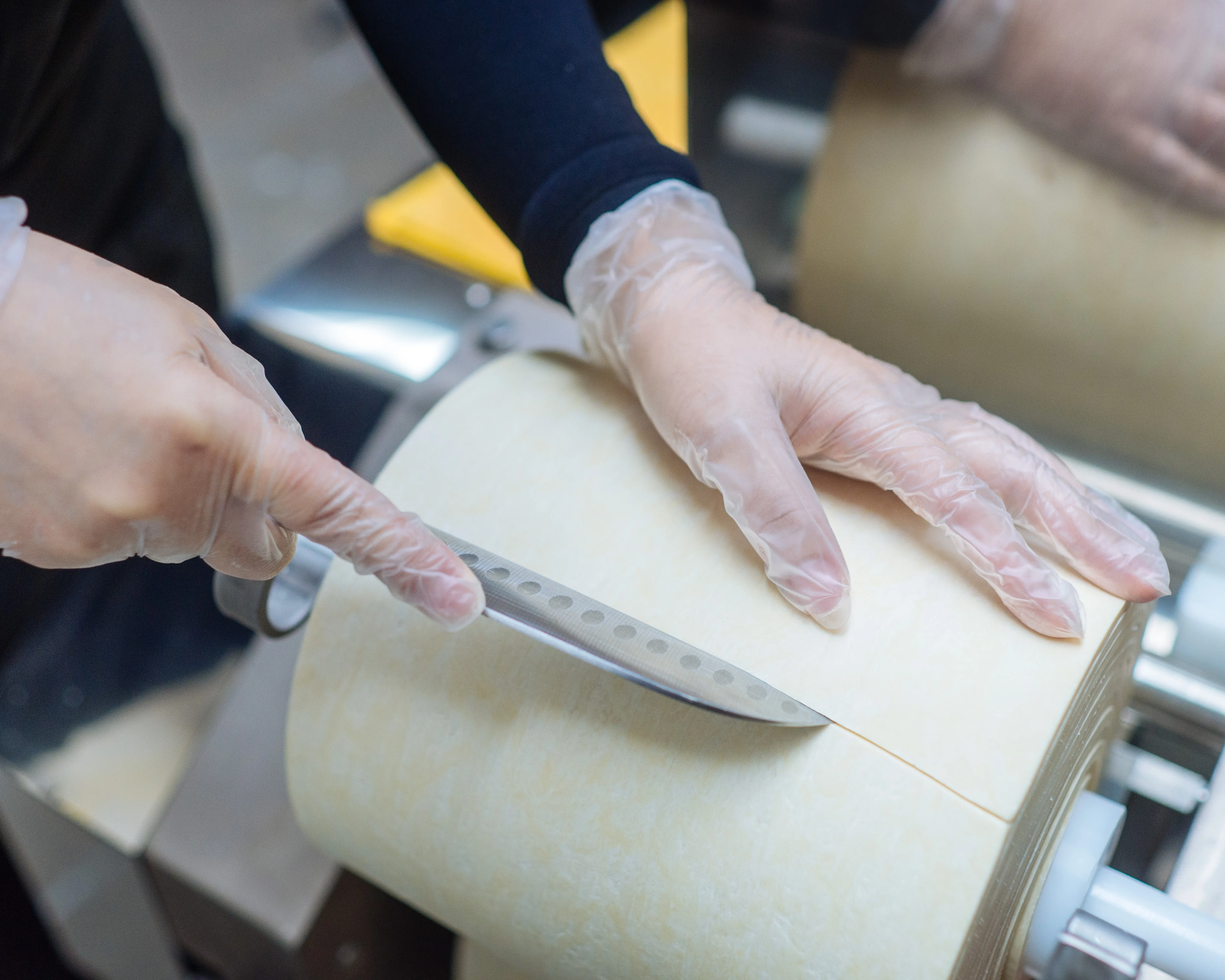 Goma Tei team member carefully preparing a sheet of fresh noodle dough.
