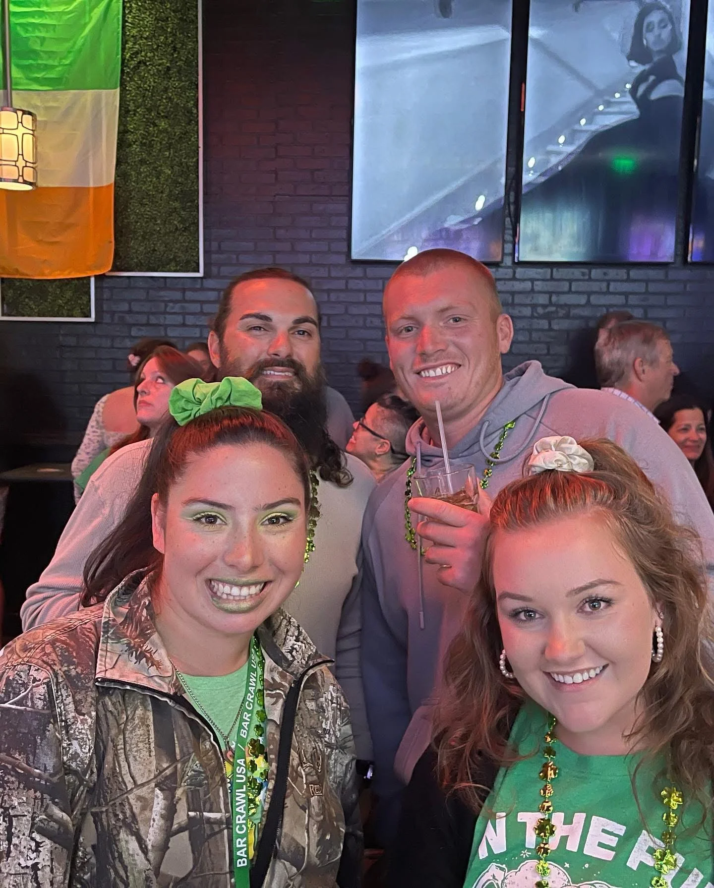 Group of friends celebrating at a lively bar with festive decorations